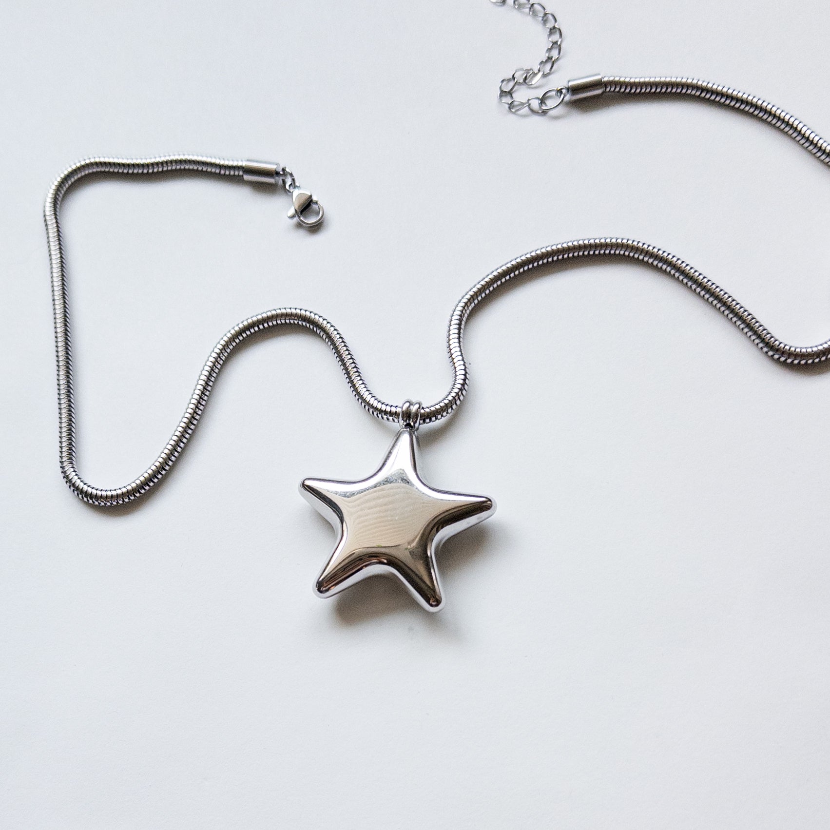 Stainless steel silver puffy star pendant on a thick snake chain.