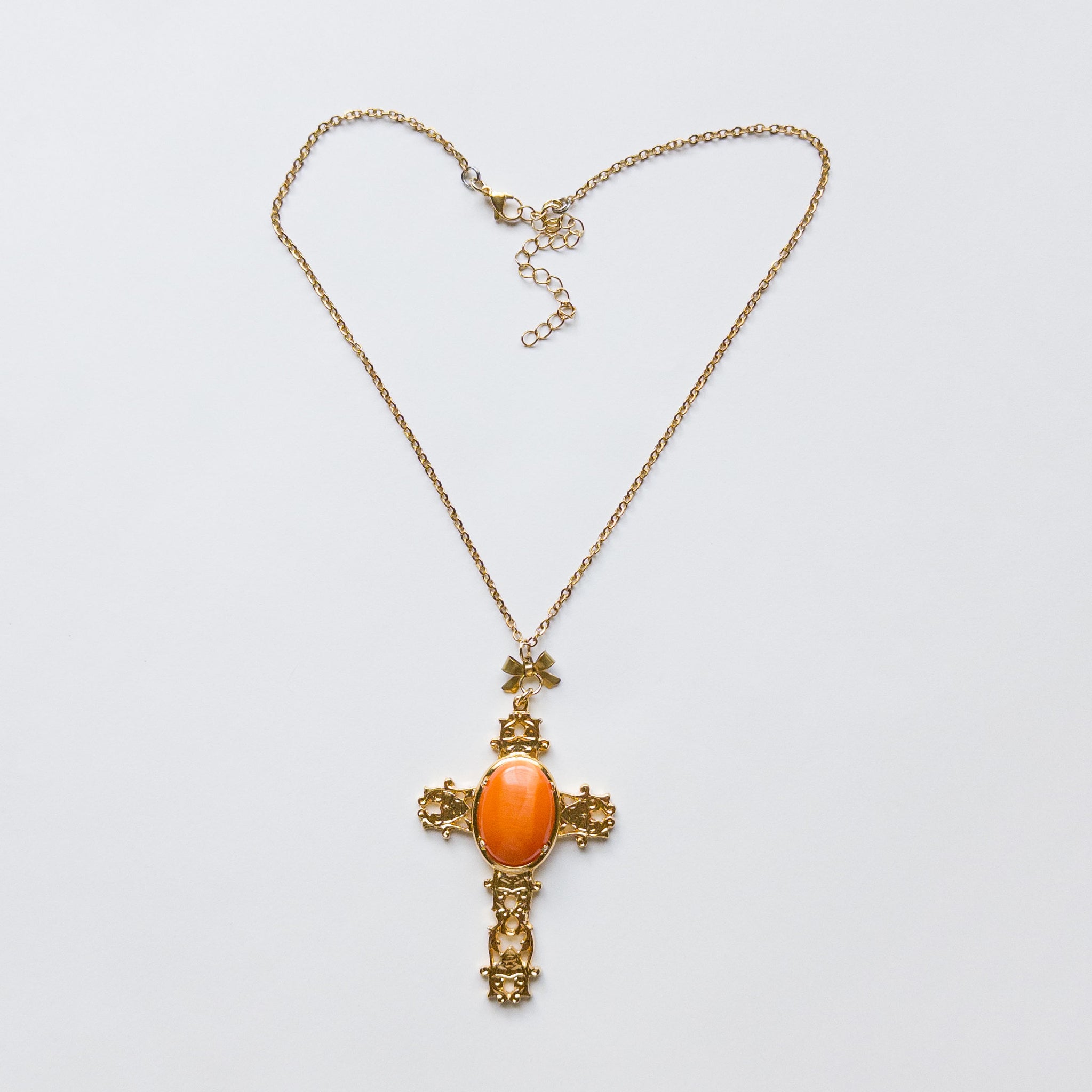 Large gold-plated cross pendant featuring an orange hue onyx stone in the center. gothic catholic ornate