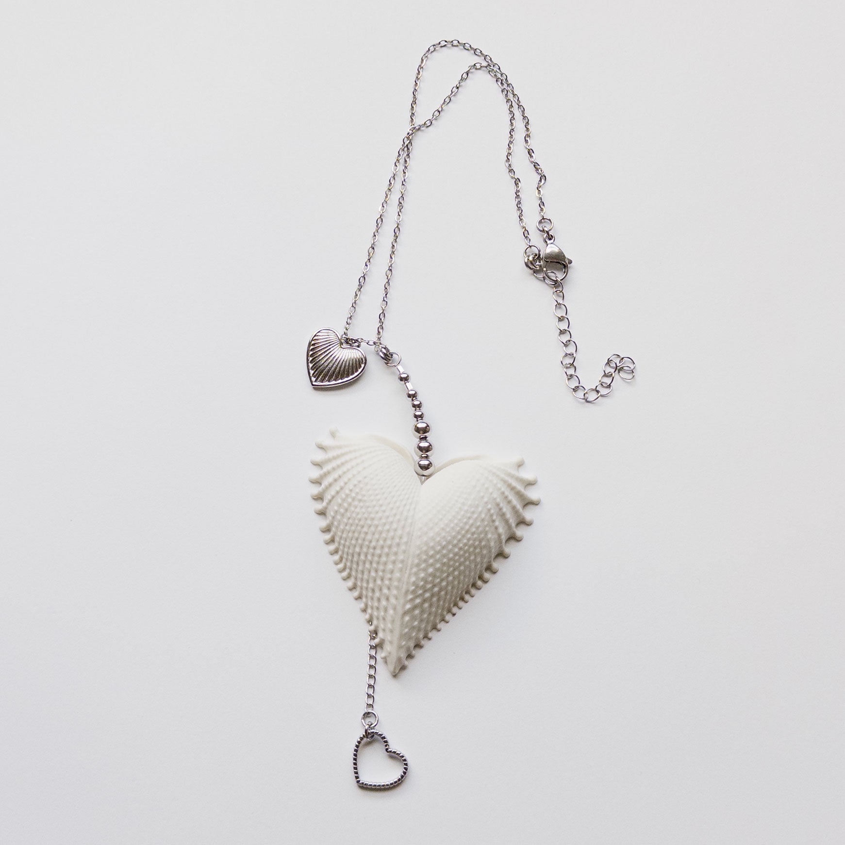 Multi charms necklace featuring a large vintage scallop heart, stainless steel heart charms, on a stainless steel chain. mermaid jewelry