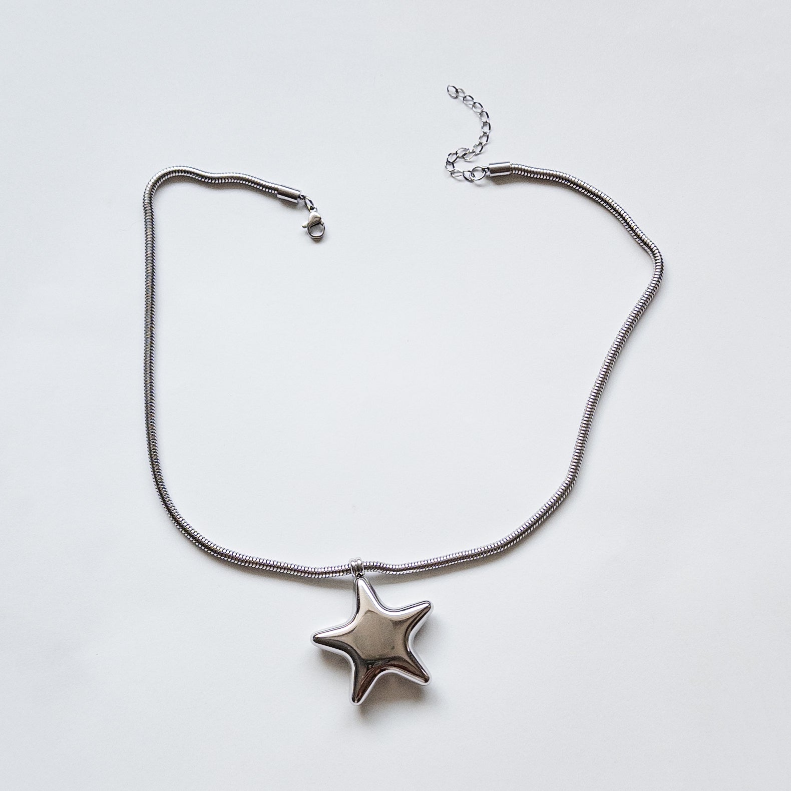 Stainless steel silver puffy star pendant on a thick snake chain necklace