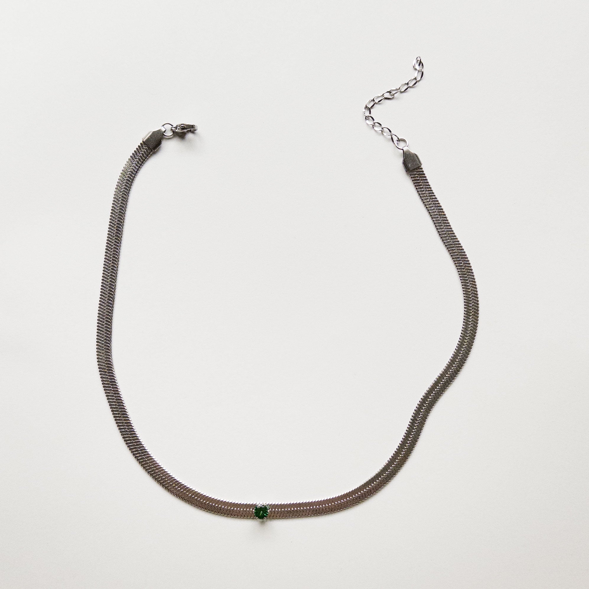 Stainless steel silver colored snake chain choker/necklace featuring a sage green cubic zirconia gem in the center. Can be dress up or down. Perfect for layering and everyday wear. 