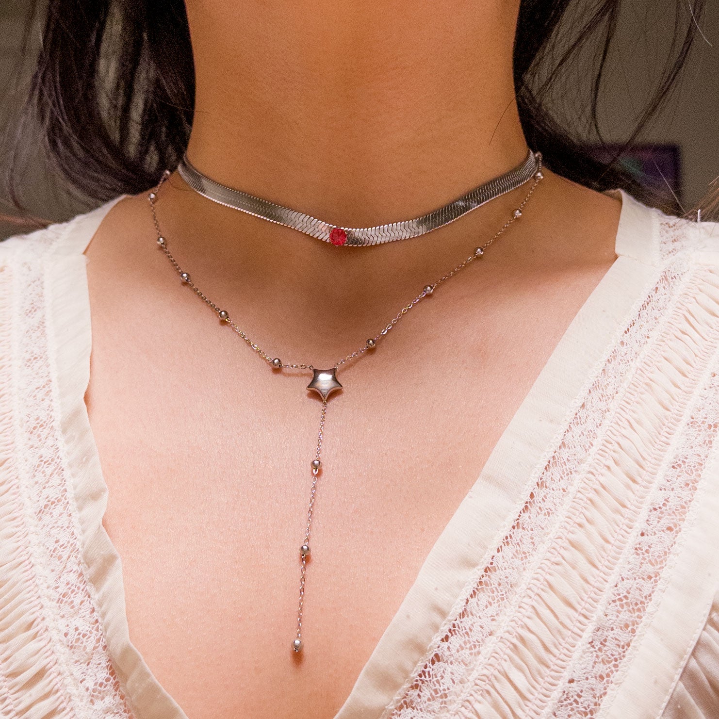 Stainless steel silver colored snake chain choker/necklace featuring a red ruby cubic zirconia gem in the center. Can be dress up or down. Perfect for layering and everyday wear. 