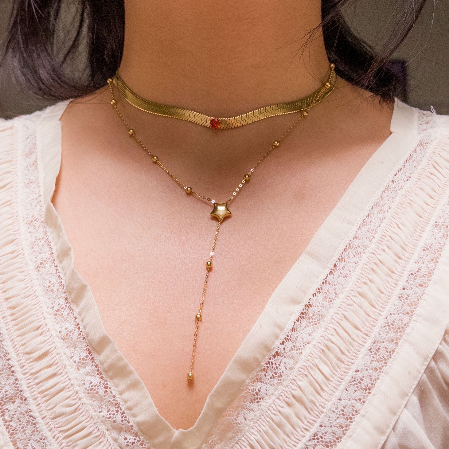 Stainless steel gold colored snake chain choker/necklace featuring a ruby red cubic zirconia gem in the center. Can be dress up or down. Perfect for layering and everyday wear. 
