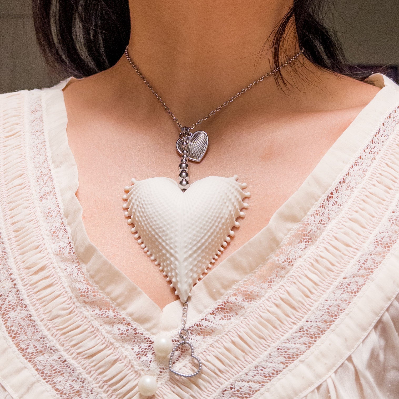 Multi charms necklace featuring a large vintage scallop heart, stainless steel heart charms, on a stainless steel chain.